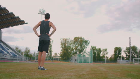 Müder-Speerwerfer.-Ein-Mann-Im-Stadion-Sammelt-Speere.-Vorbereitung-Auf-Den-Mehrkampf.-Nach-Dem-Training-Im-Hintergrund-Der-Tribüne-Durch-Das-Stadion-Laufen-Und-Speere-Zum-Werfen-Tragen.